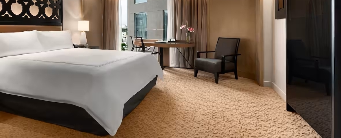 Cama de hotel vestida con sábanas y almohadas blancas